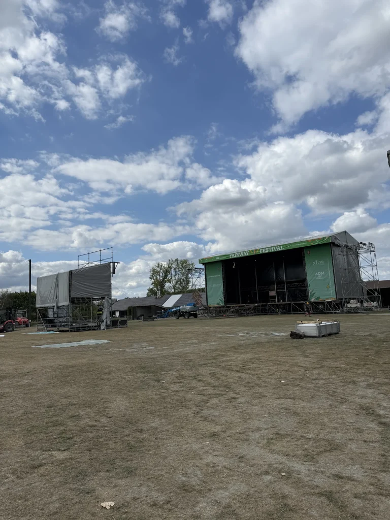 Podia in opbouw op de golfweide van Fairway Festival 2025