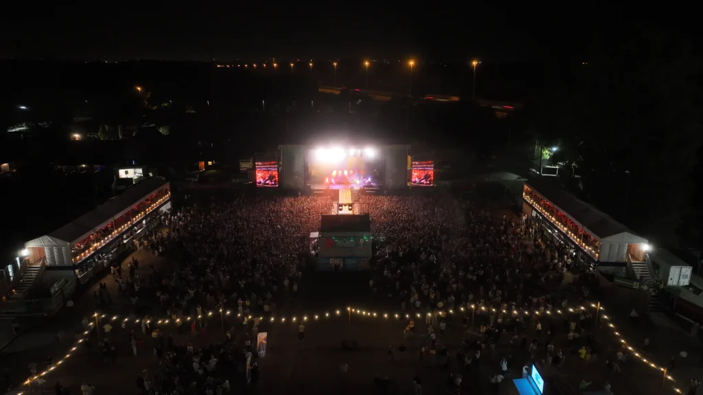 Luchtbeeld bij nacht van Fairway Festival 2025: mainstage en publiek