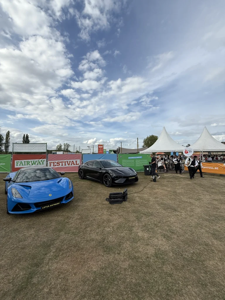 Sportwagens en partnerbranding aan de ingang van Fairway Festival