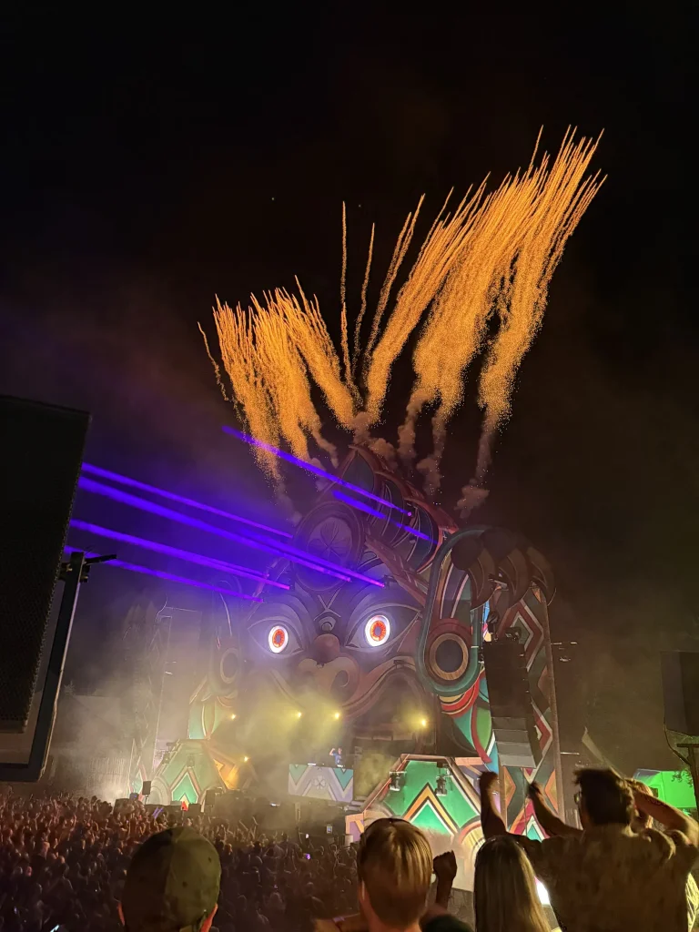 Vuurwerk en vlammen boven de mainstage van Magic Island 2025 bij nacht