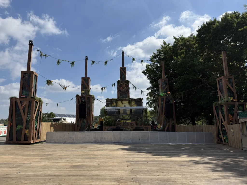 Houten podiumtorens met vlaggetjes op een stage van Magic Island 2025