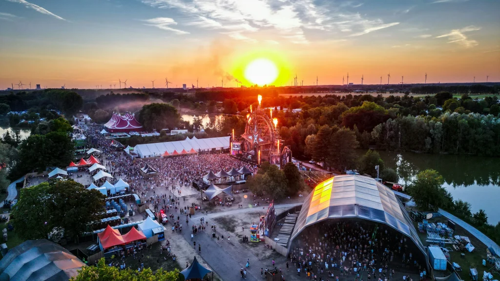 Zonsondergang boven het festivalterrein van The Qontinent 2022 vanuit de lucht