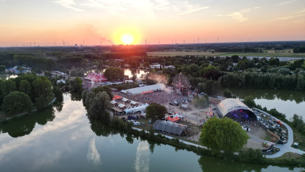 Festivalterrein van The Qontinent 2022 tussen de meren, luchtbeeld bij zonsondergang