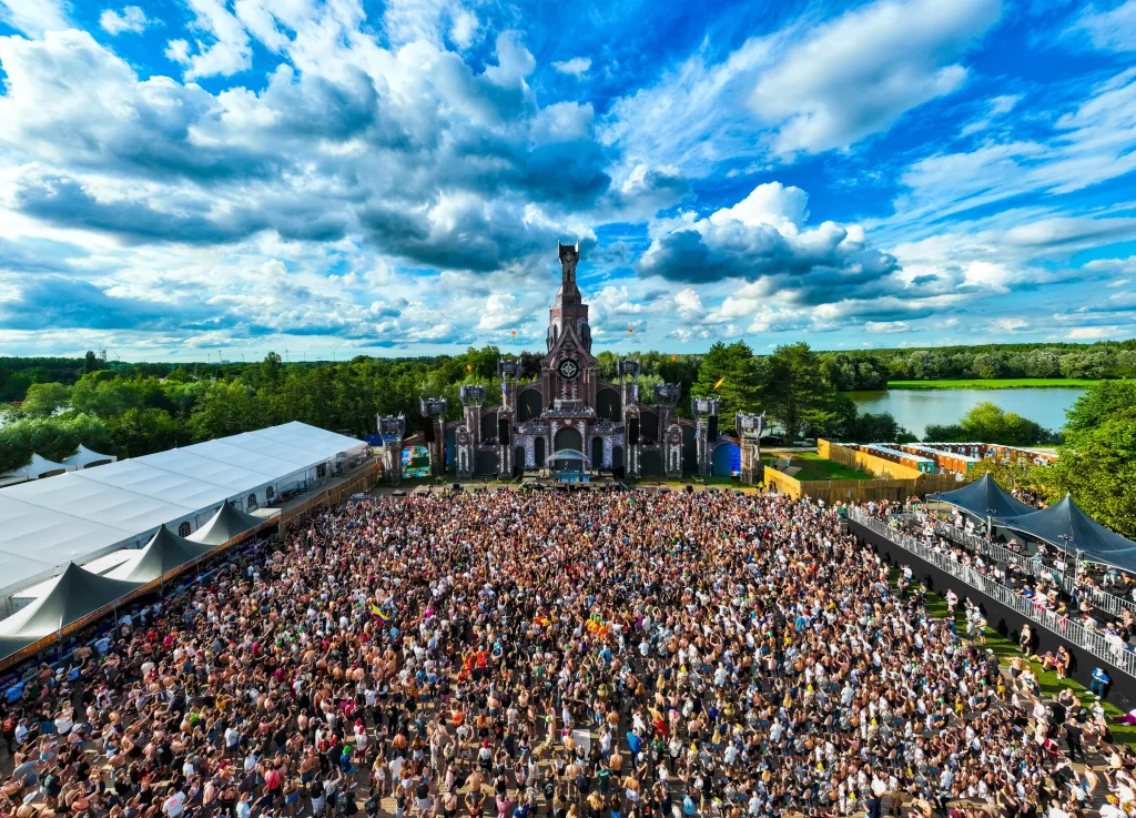 Volle mainstageweide op The Qontinent 2023 onder een wolkenlucht, luchtbeeld