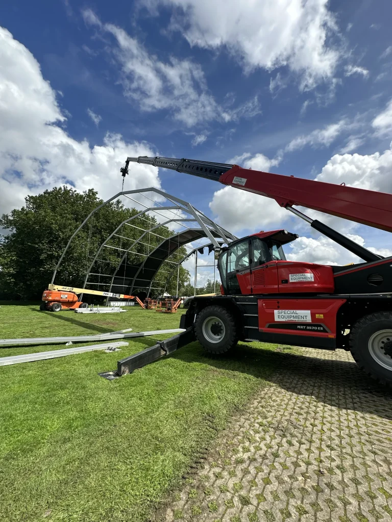 Verreiker monteert een tentspant tijdens de opbouw van The Qontinent 2023