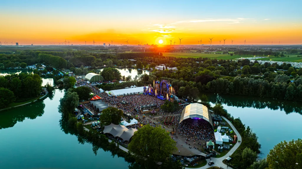 Festivalterrein van The Qontinent 2024 tussen de meren bij zonsondergang, luchtbeeld