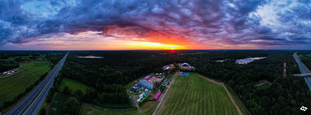 Panorama vanuit de lucht over Sunrise Festival 2022 en de E34 bij zonsondergang