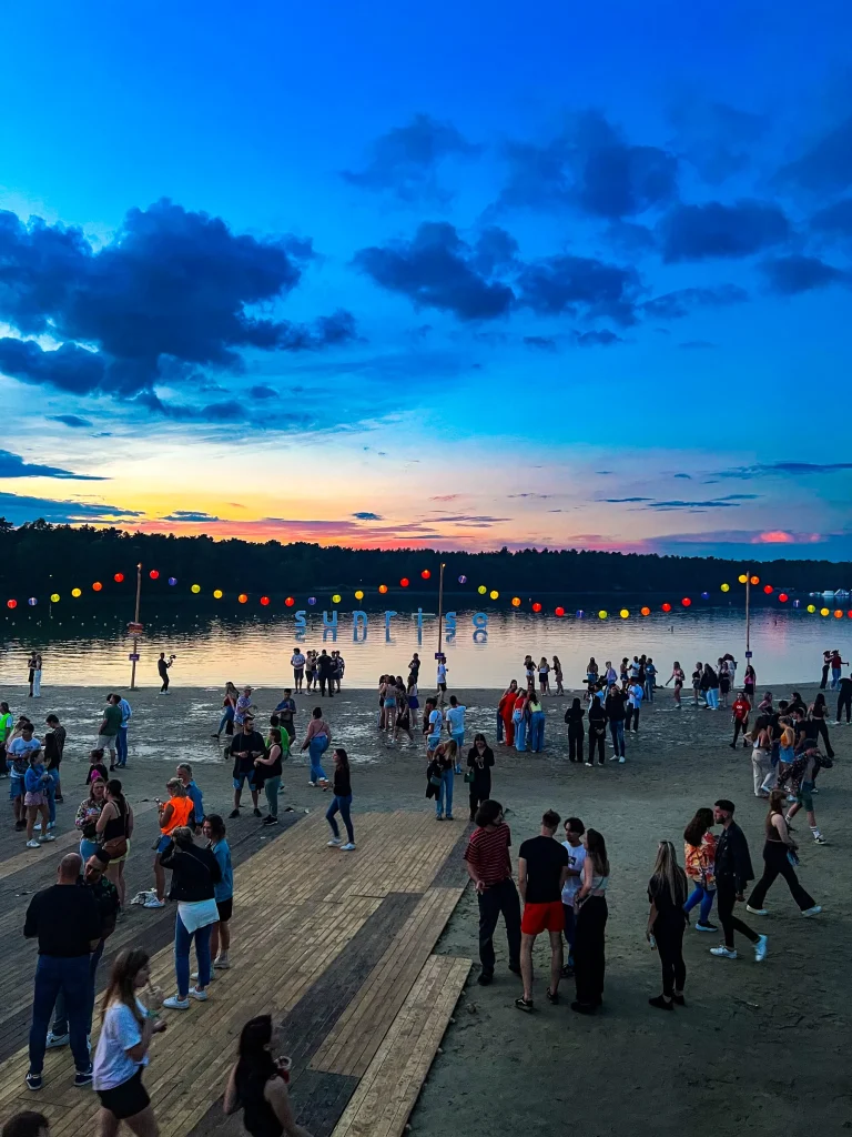 Festivalgangers op het strand van De Lilse Bergen bij valavond tijdens Sunrise 2022