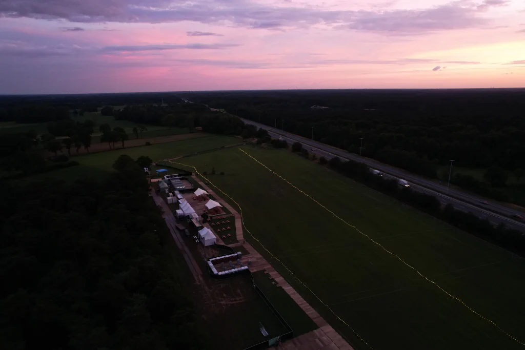 Festivalterrein en E34 bij schemering, luchtbeeld van Sunrise Festival 2022