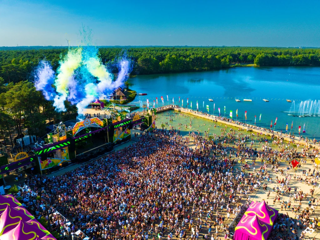 Mainstage met gekleurde rook en volle weide aan het meer, Sunrise Festival 2023