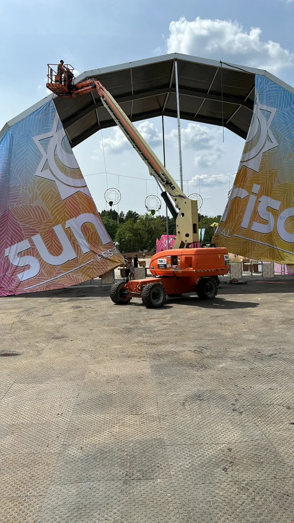 Hoogwerker bij de entreeboog van Sunrise Festival 2023 tijdens de opbouw