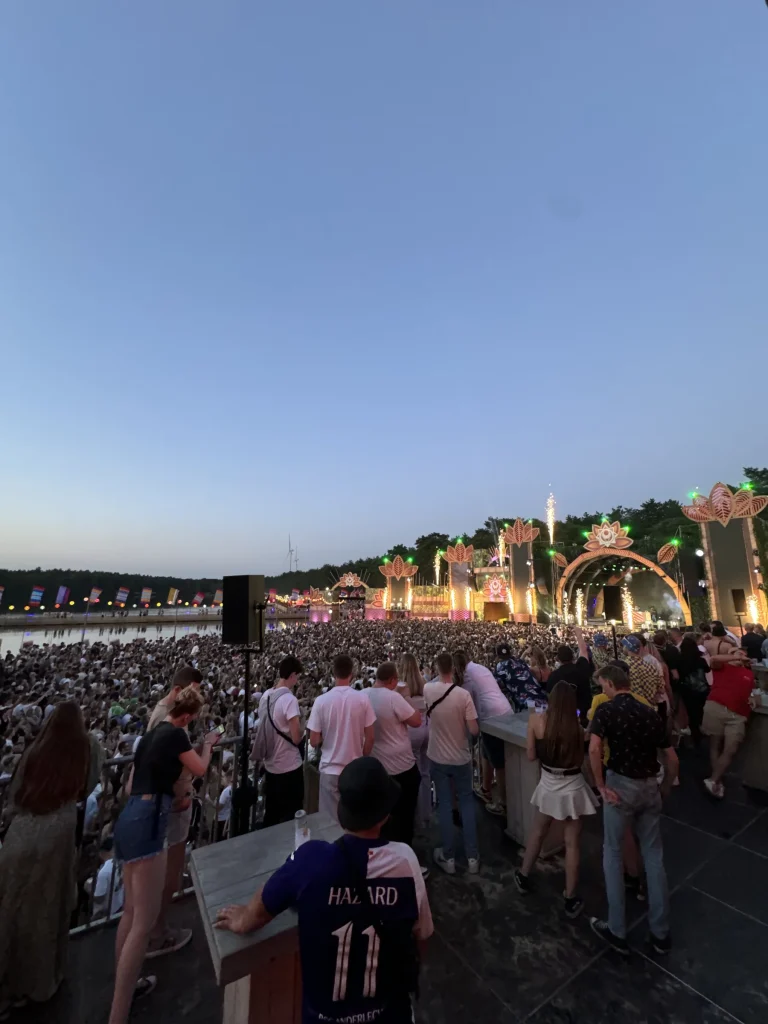 Zicht van op een verhoog over het publiek en de mainstage van Sunrise Festival 2024