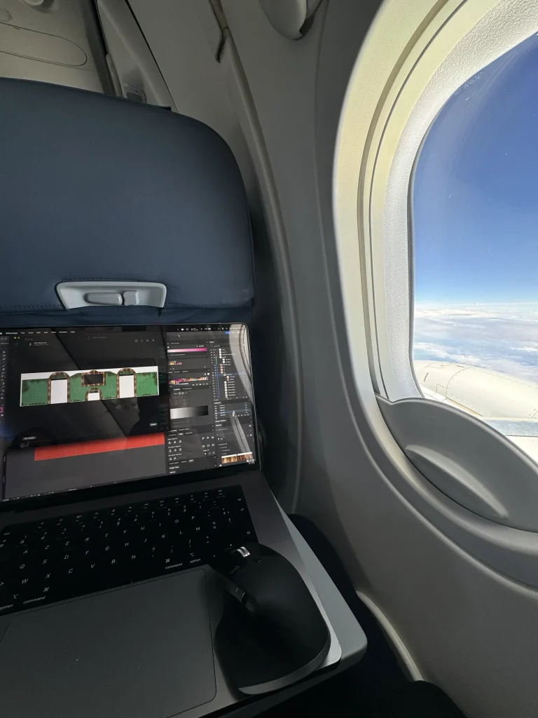 Laptop met festivalplan aan boord van een vliegtuig