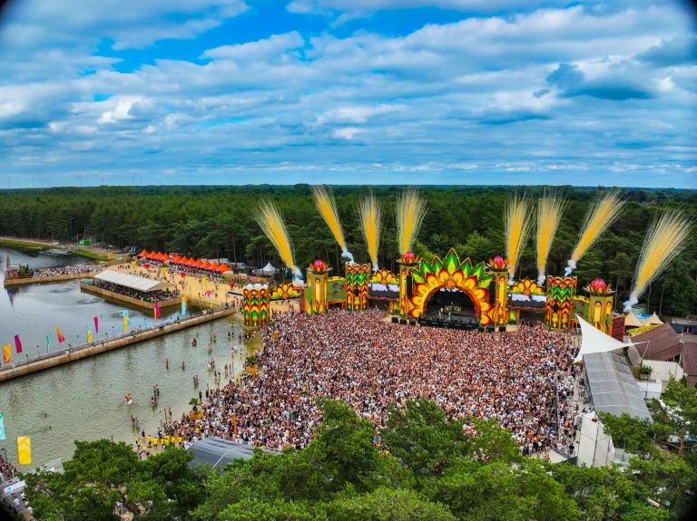 Sunrise Festival 2025 main stage with flames and a packed lakeside field, aerial
