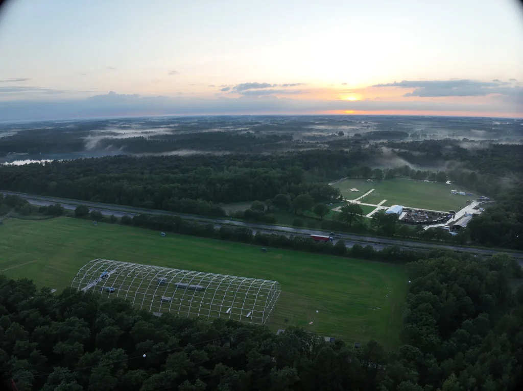 Festivalweide met tentspanten in opbouw bij zonsopgang, luchtbeeld Sunrise Festival 2026