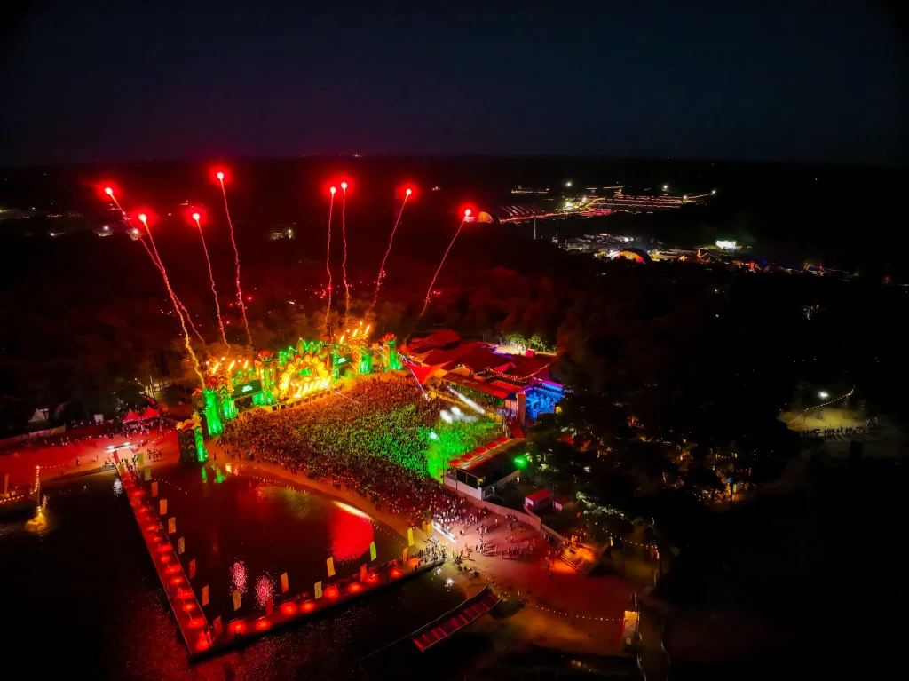 Rood vuurwerk boven de mainstage en het meer bij nacht, luchtbeeld