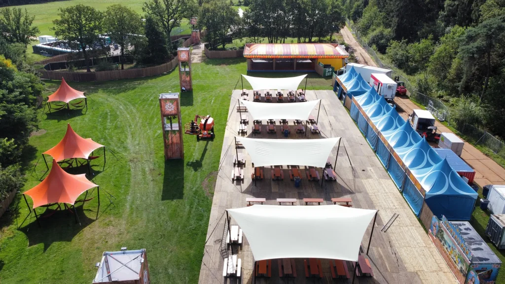 Barzone met schaduwdoeken en picknicktafels op Sunset Festival 2021, luchtbeeld