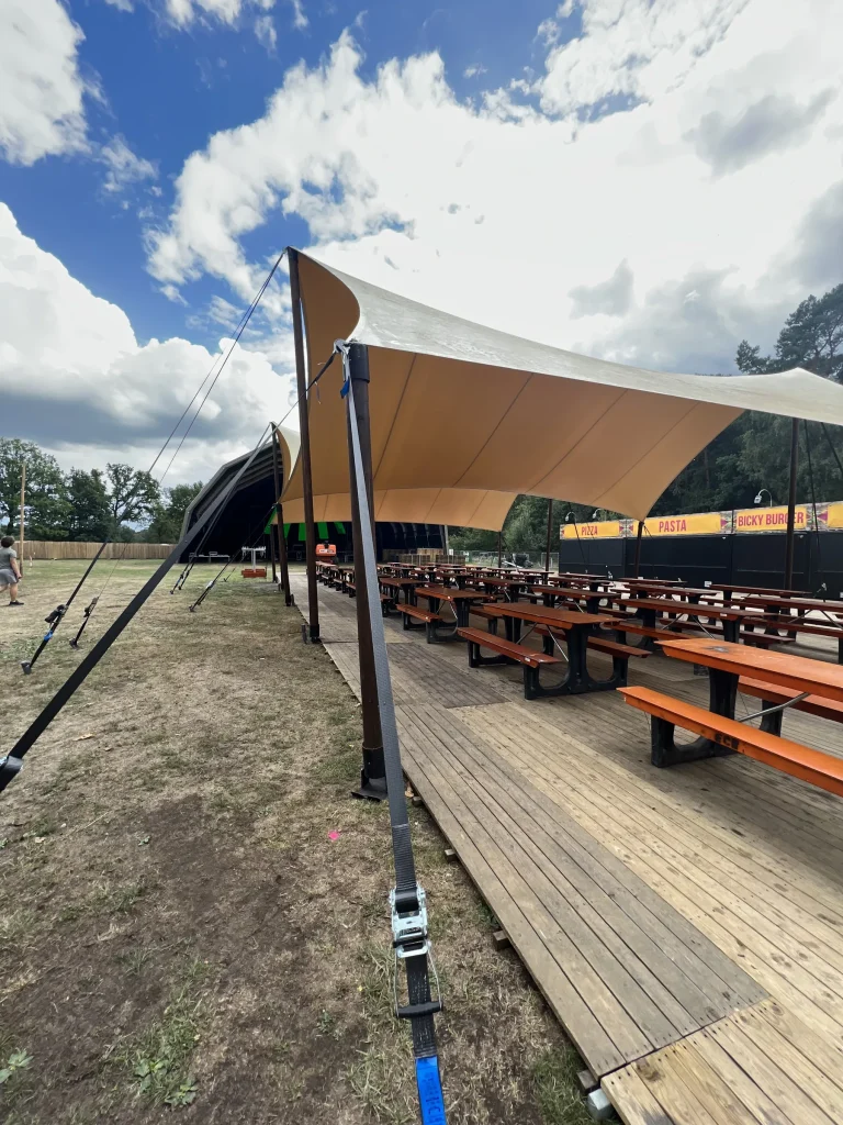 Schaduwdoek boven picknicktafels op Sunset Festival 2022