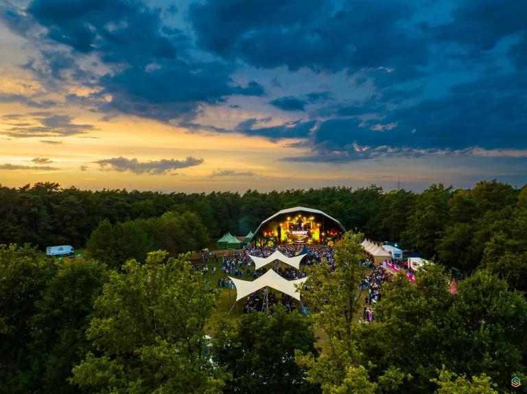Sunset Festival 2025 among the trees under an evening sky, aerial
