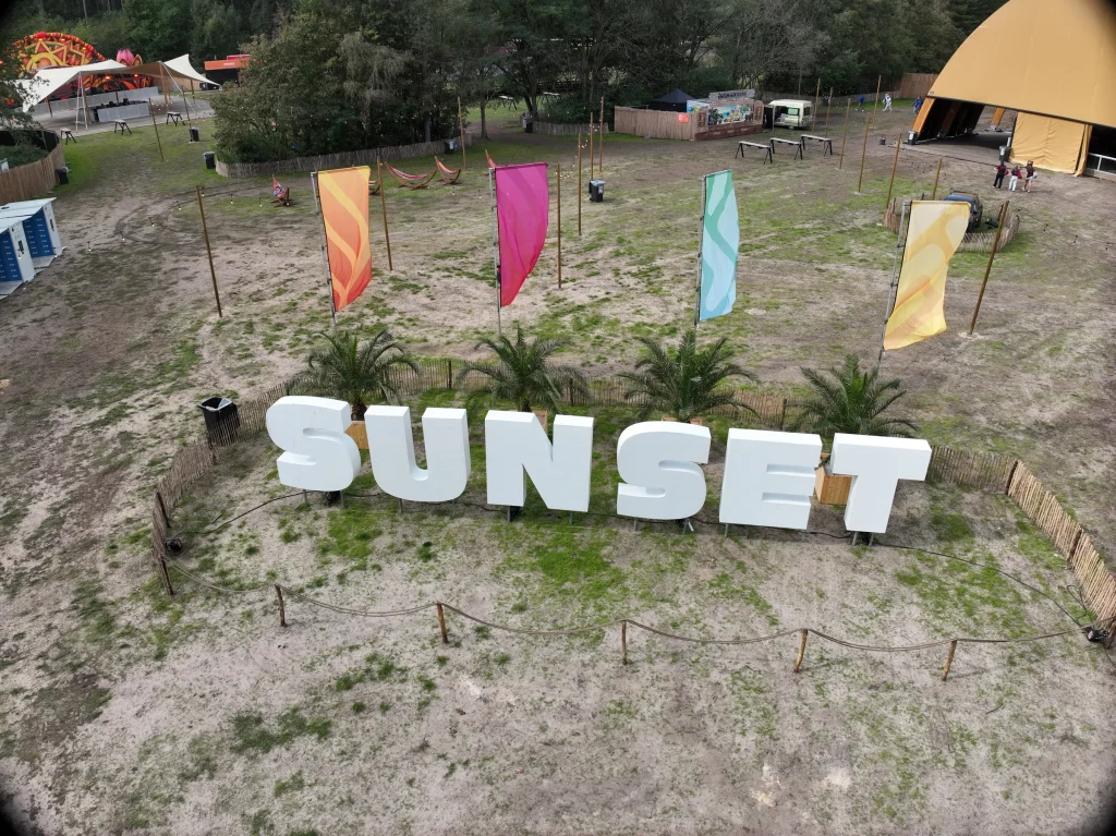 SUNSET-letters en vlaggen op het festivalterrein, luchtbeeld