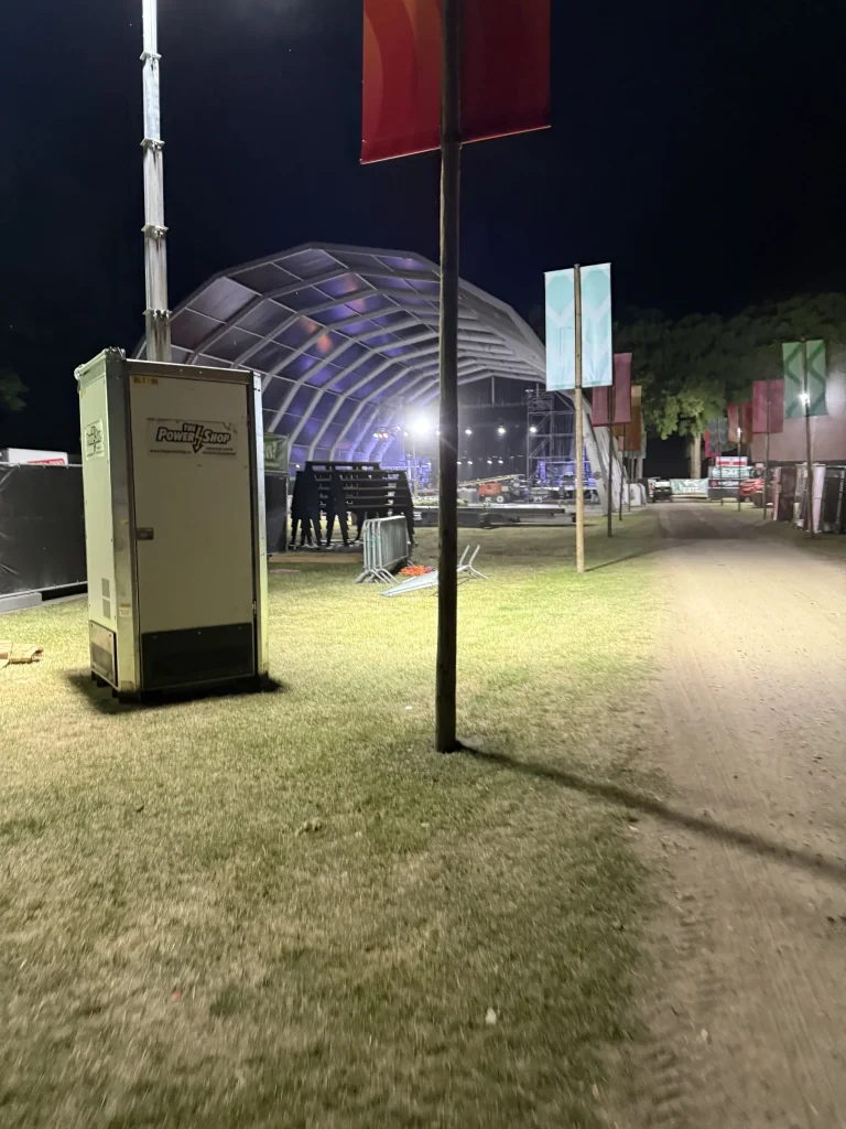 Festivalpad met verlichte tent en vlaggen bij nacht op Vagebond Weekend 2025