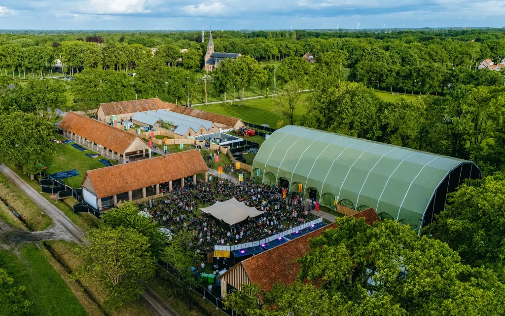 Luchtbeeld van Vagebond Weekend 2026 met festivaltent, binnenplein en kerk van Merksplas-Kolonie