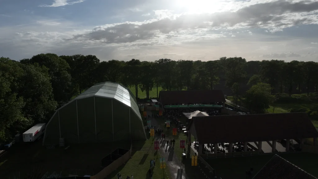 Festivaltent en schuren in tegenlicht, luchtbeeld Vagebond Weekend 2026