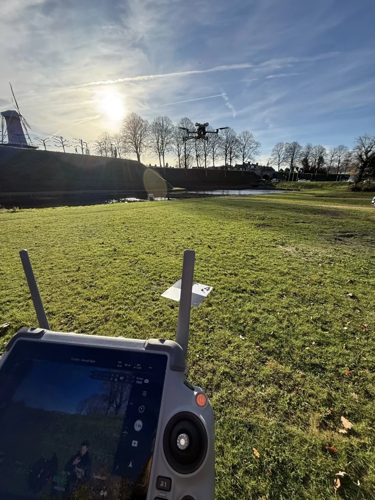 Mapping drone in the air above the Hulst ramparts, controller in the foreground